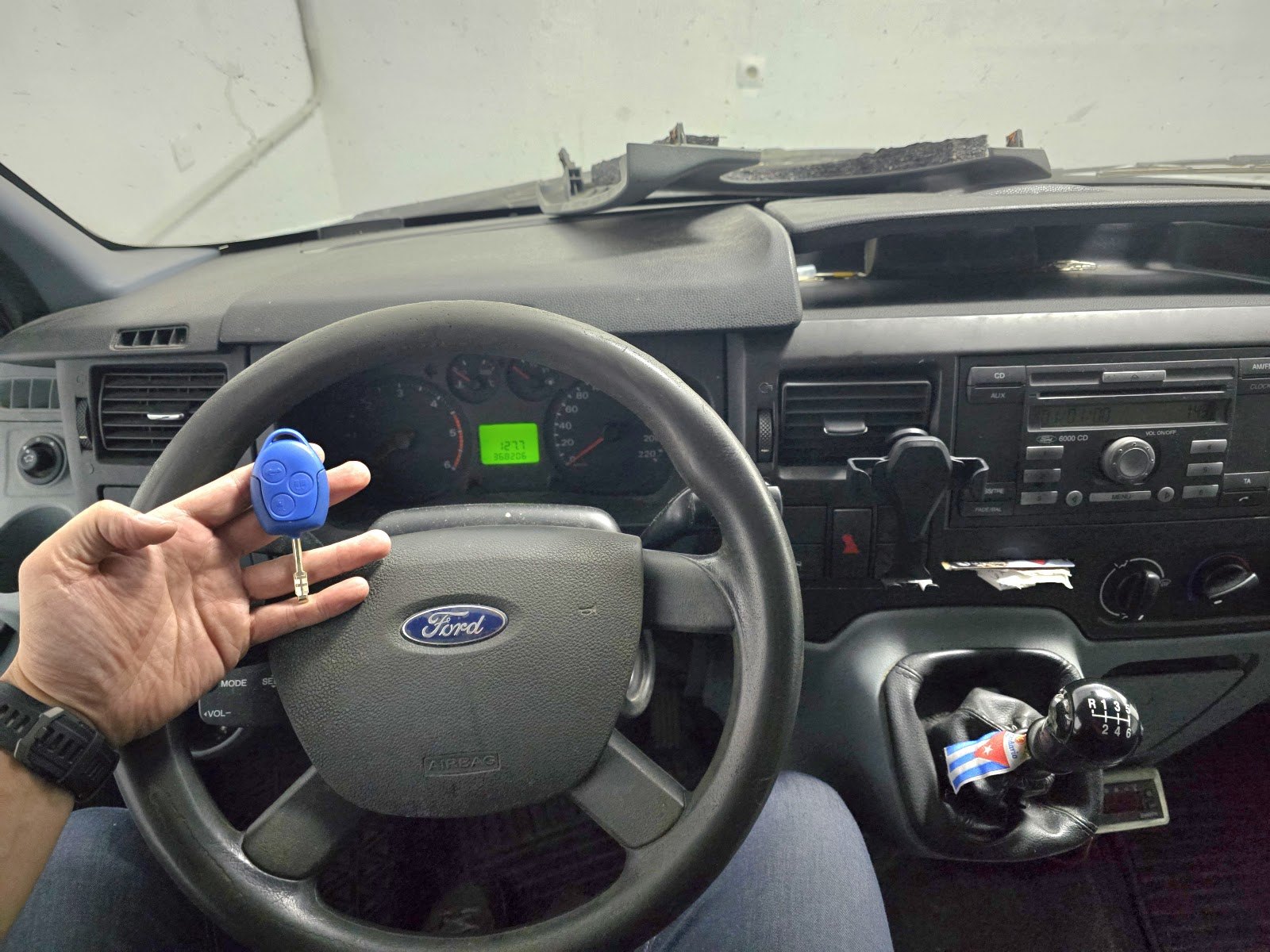Llave azul de furgoneta Ford sostenida delante del volante