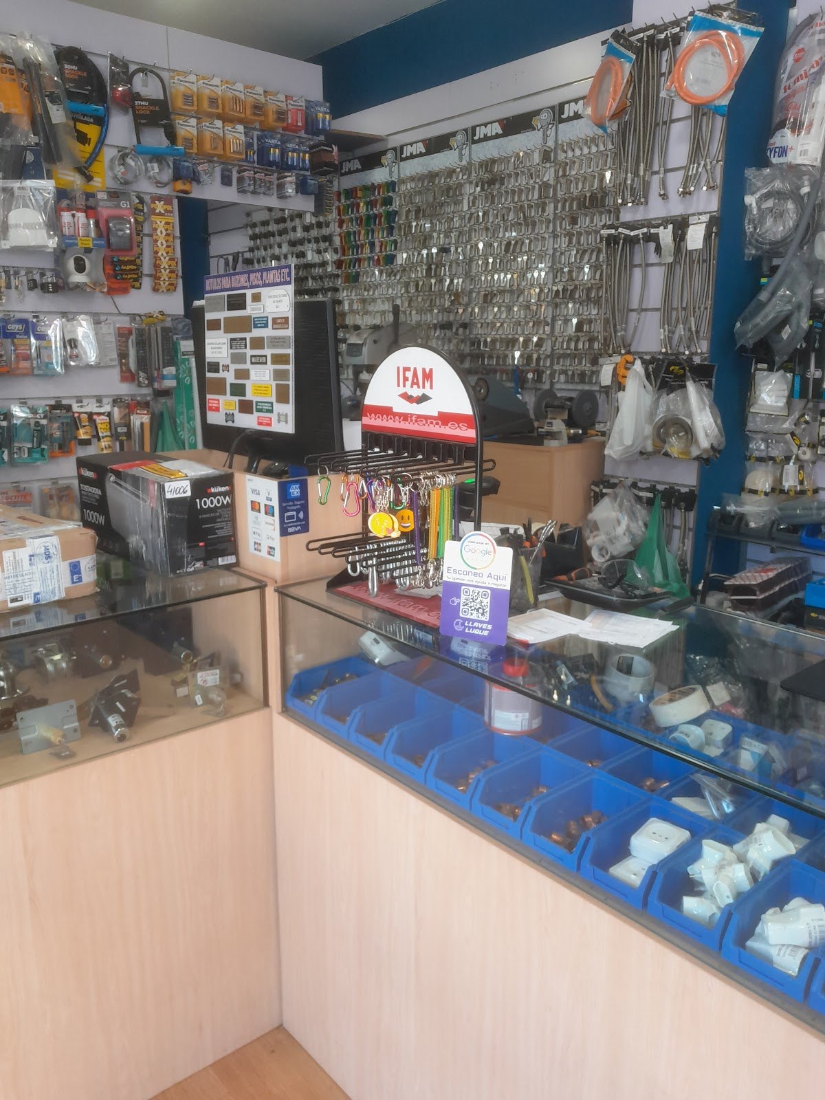 Mostrador de la tienda con llaves en bruto, candados y herramientas colgadas en la pared